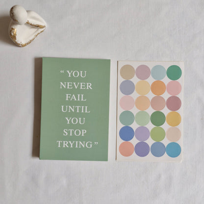 Motivational card with colorful dot pattern and inspirational quote on a light gray background