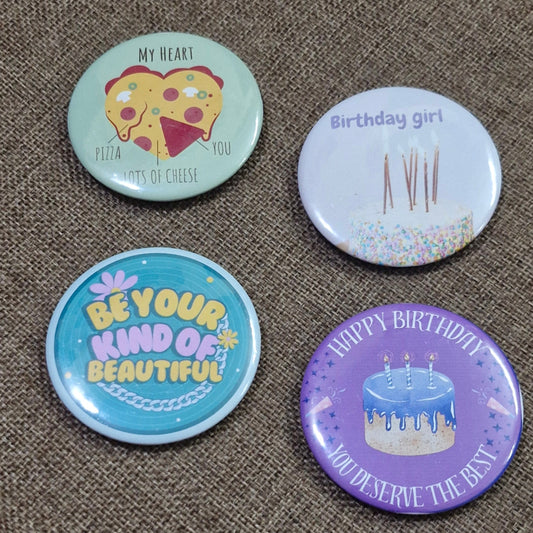Four colorful buttons with different designs on a textured surface