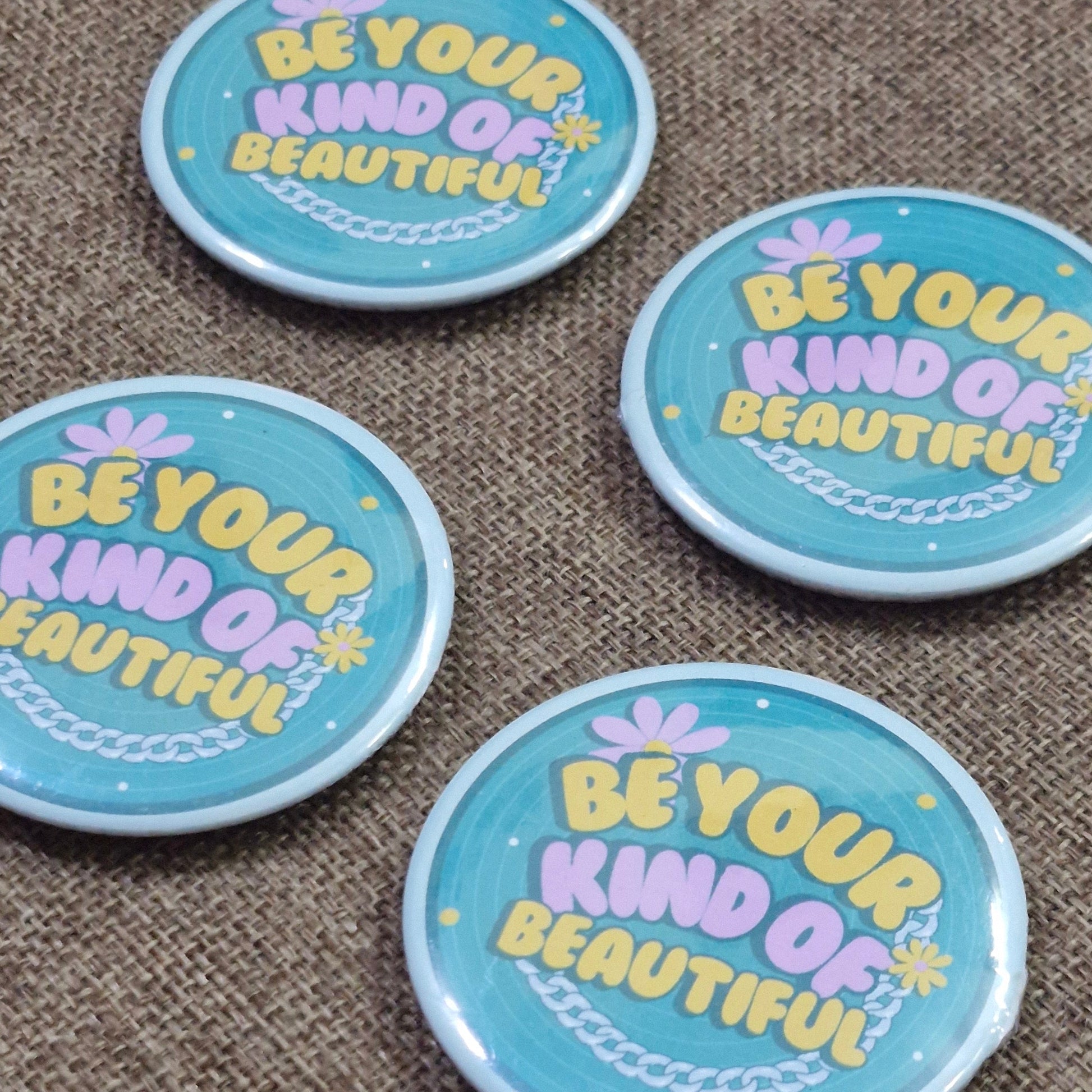 Four round buttons with motivational text on a textured surface